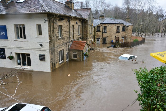 Floods rip through a street in Ireland, submerging cars.