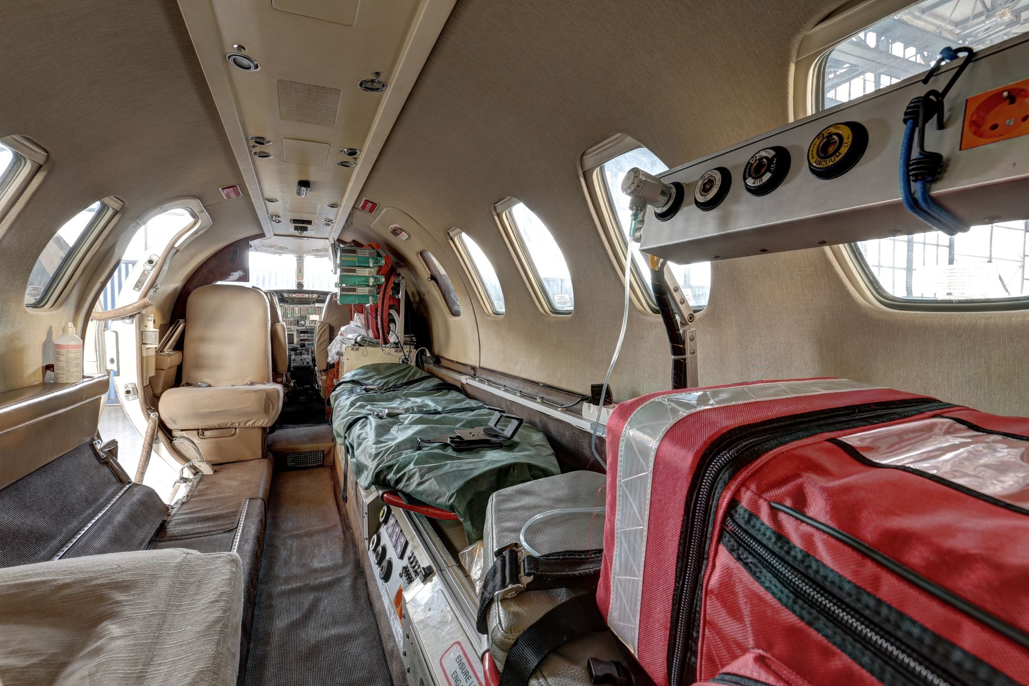 Interior de un avión de evacuación médica equipado con una camilla, material médico y equipo de monitorización, listo para el transporte de pacientes.