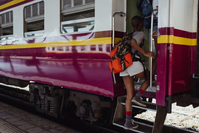A young woman boards a train.