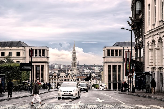 A man crosses the road on a crosswalk in downtown Brussels, Belgium.