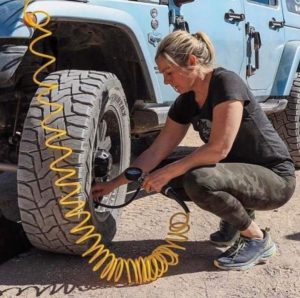 Mom woman filling off road vehicle tire with air