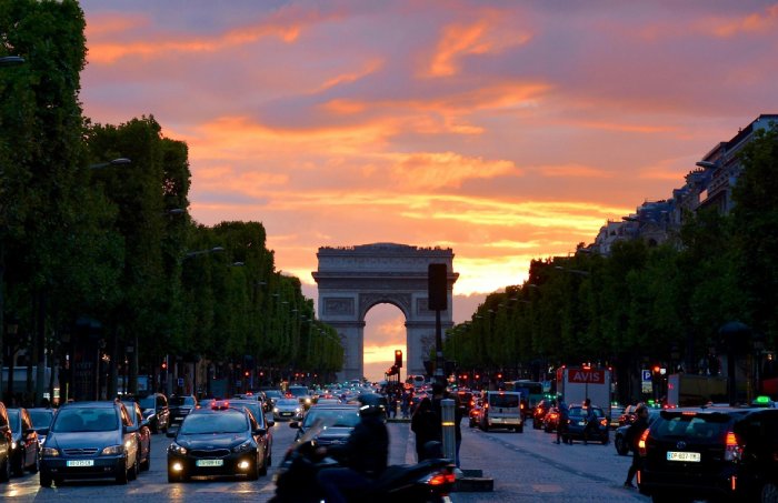 The Champs Elysees with the Arc de Triomphe and traffic at sunset.