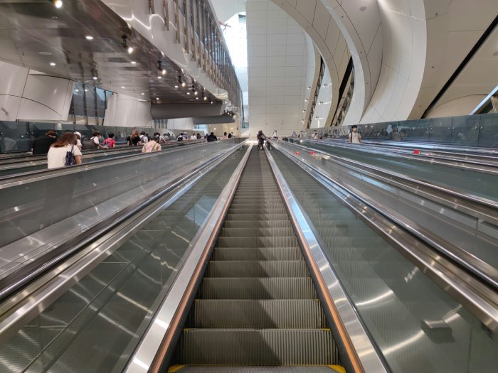 A view from the bottom of an empty escalator looking up.