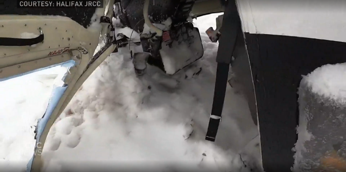 The upside-down cockpit of a helicopter after crashing on a frozen lake.