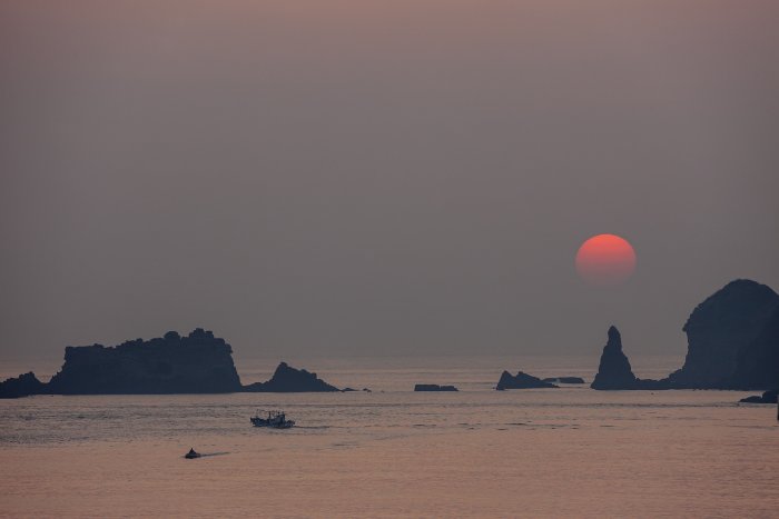 The sun sets over the sea near Jeju Island, South Korea