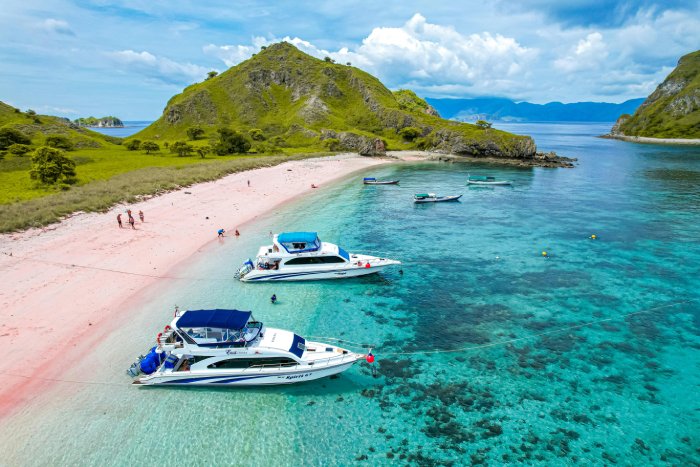 Two boats anchored on a tropical beach.