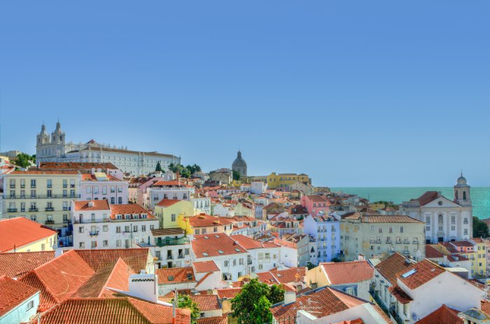 Orange stucco rooftops and church steeples in Lisbon