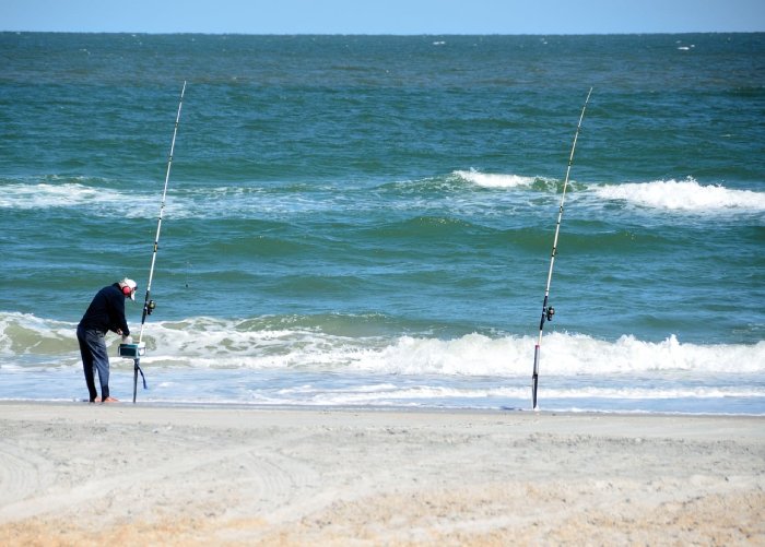 A surfcaster fishing on the beach in the Outer Banks, NC