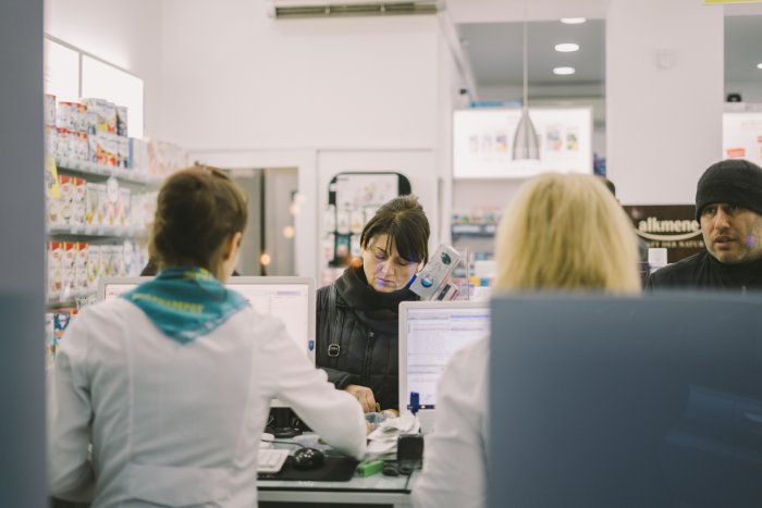 Customers picking up medication from a pharmacy in the country of Georgia.