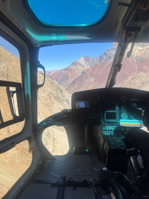 The view from inside a rescue helicopter while flying low in the mountains in the Andes.