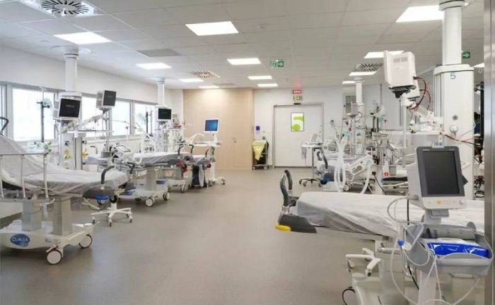 A well-lit hospital room filled with modern hospital beds and medical equipment.