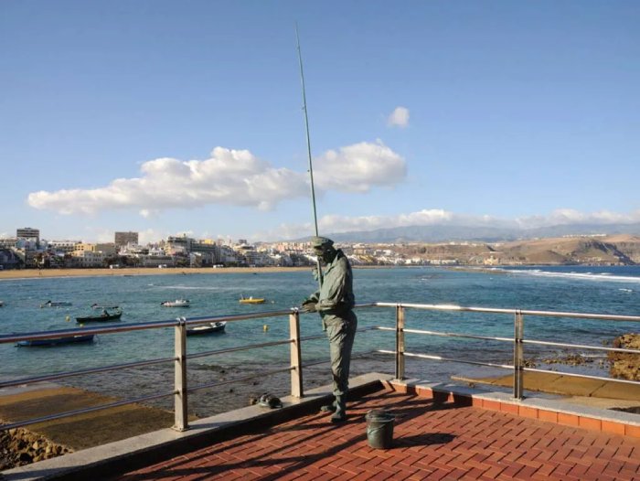 A statue of a fisherman on a pier in the Canary Islands, Spain.