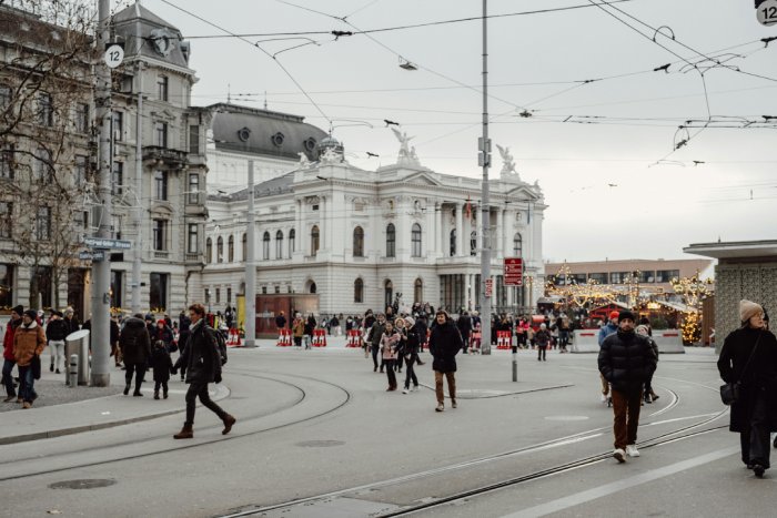 People walking on a street in downtown Zurich in the cold.