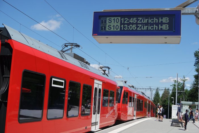 A red city train stops at a station in Zurich, Switzerland.