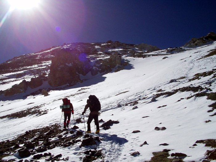 Two climbers ascend Aconcagua under a bright sun.
