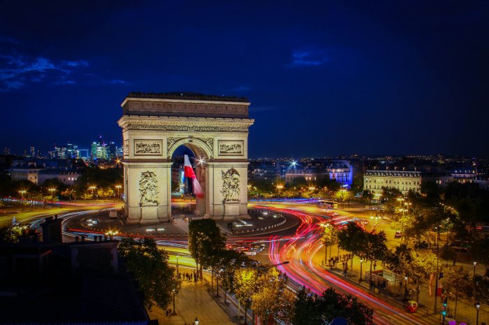 L'Arc de Triomphe at night with a blur or red and yellow car lights from passing traffic.