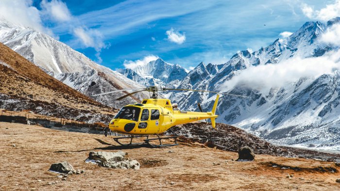 A yellow rescue helicopter on a mountain.