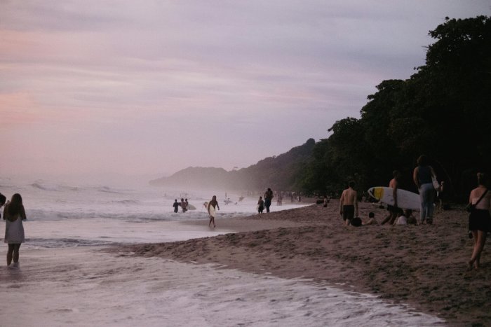 A Costa Rican beach filled with surfers and people.