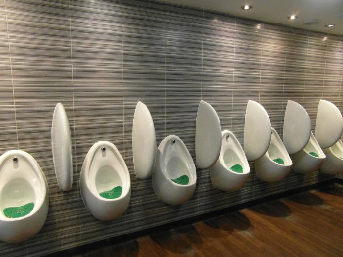 A row of urinals in a clean men's public bathroom